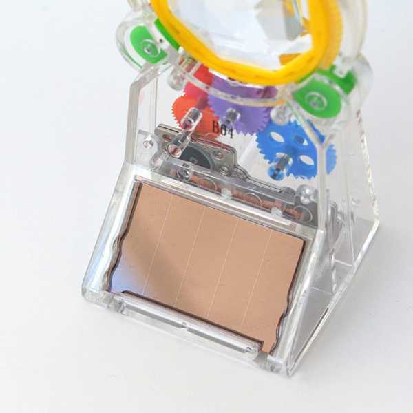 ソーラーパネルに太陽光が当たると中のハグルマが動きだしクリスタルを回転させます。