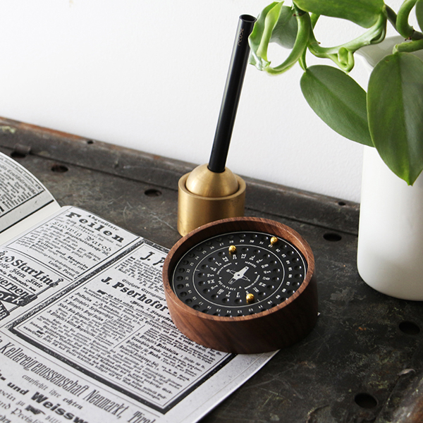 書斎などのアクセントになる、重厚感と木目のあたたかみを兼ね備えた万年カレンダー。