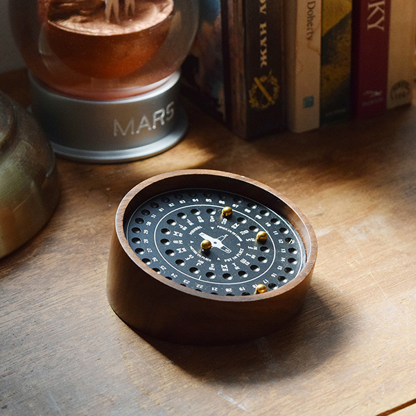 書斎などのアクセントになる、重厚感と木目のあたたかみを兼ね備えた万年カレンダー。