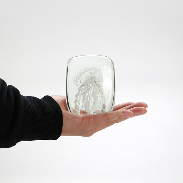 四角い水の中に１匹のクラゲが浮遊しているかのようなガラス製オブジェ。