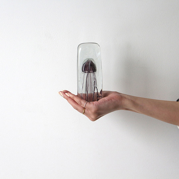 四角い水の中に１匹のクラゲが浮遊しているかのようなガラス製オブジェ