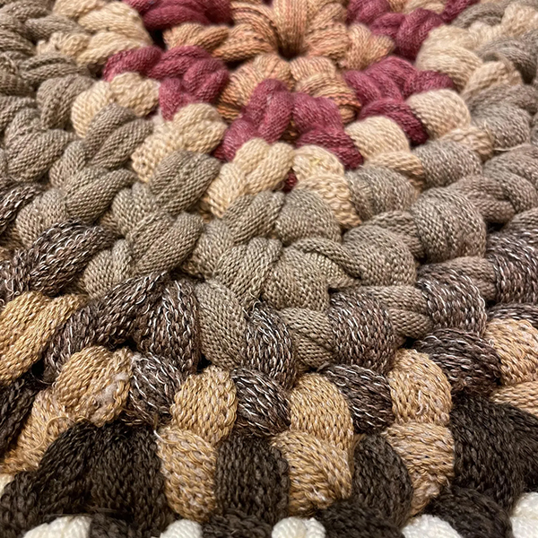 靴下を製造すると必ず出る輪っかの端切れを指編みという技法で編んだマット。