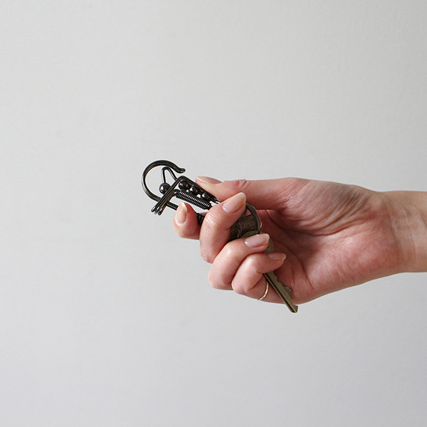 どこかスチームパンクのような雰囲気を持ち合わせた、１本の鋼線を曲げて仕立てたカラビナ。