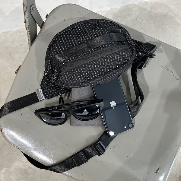 格子柄部分に反射糸を使った素材を使用したファニーパック。