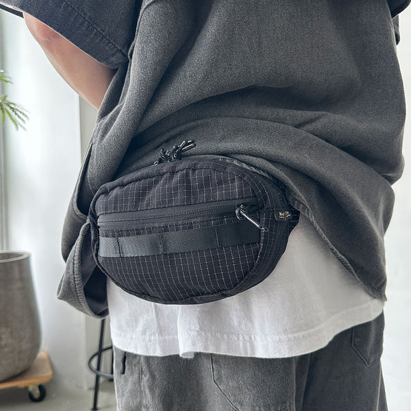 格子柄部分に反射糸を使った素材を使用したファニーパック。