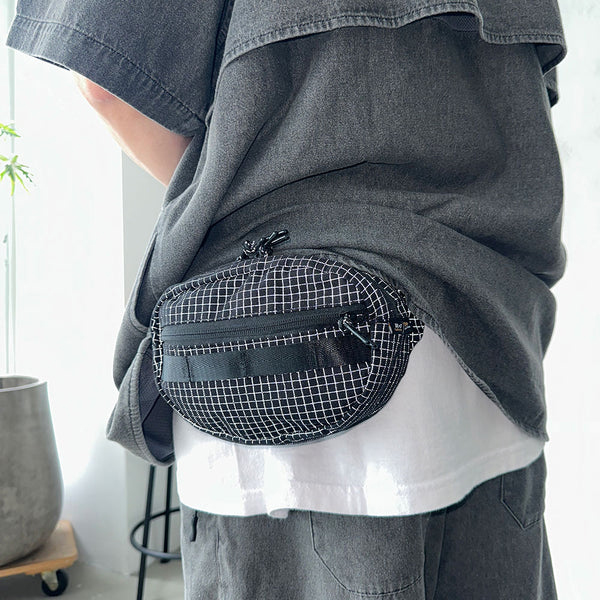 格子柄部分に反射糸を使った素材を使用したファニーパック。