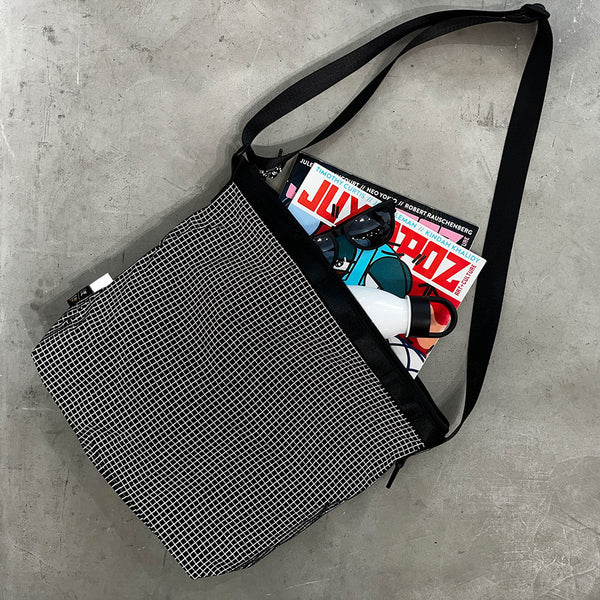 格子柄部分に反射糸を使った素材を使用したショルダーバッグ。