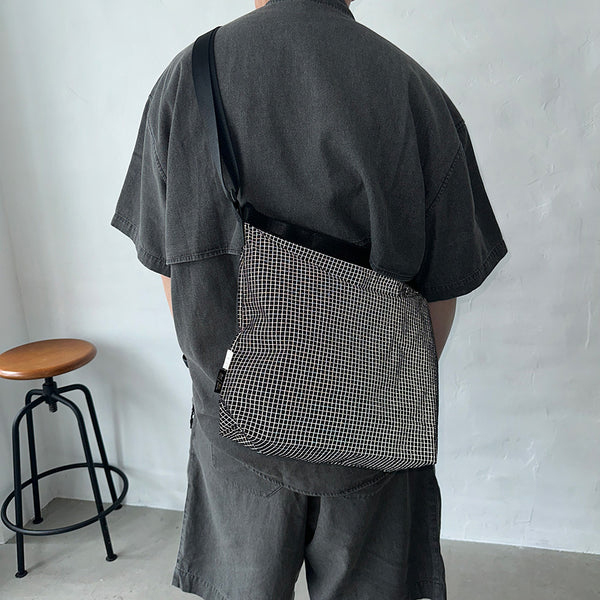 格子柄部分に反射糸を使った素材を使用したショルダーバッグ。