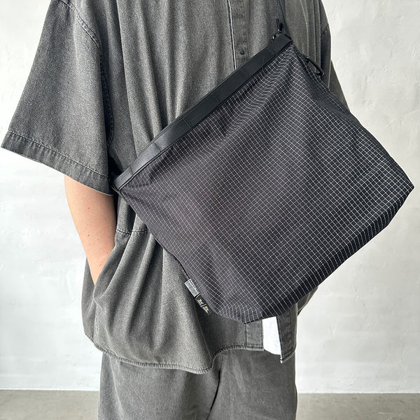 格子柄部分に反射糸を使った素材を使用したショルダーバッグ。