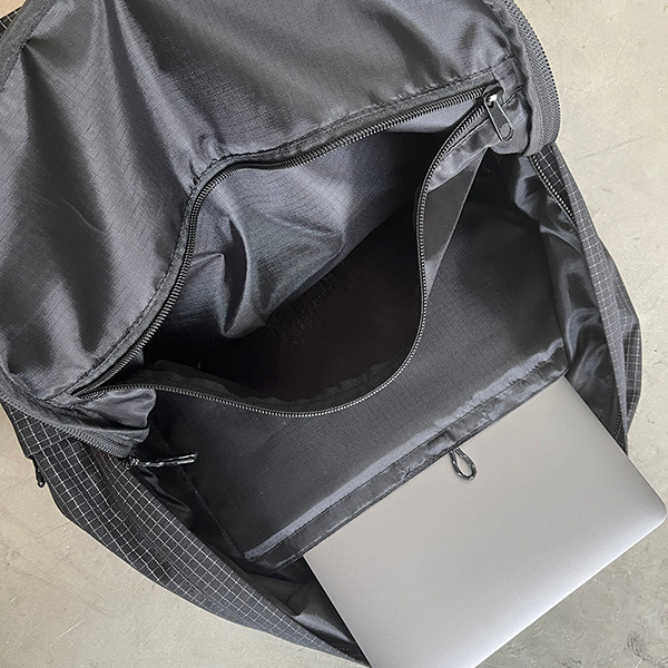 リップストップ生地の特徴である格子柄部分に反射糸を使った素材を使用したバックパック。